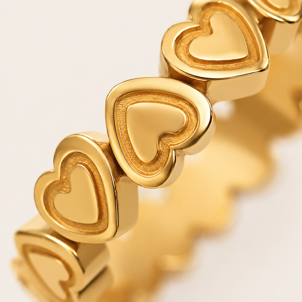 A close-up of a gold heart-link ring.