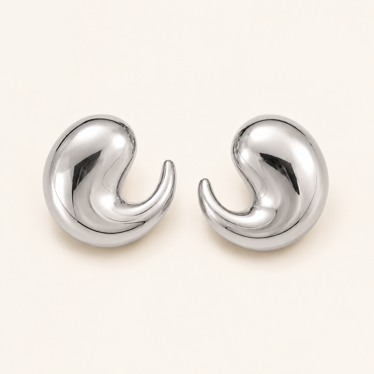 A pair of polished silver-toned crescent-shaped earrings.