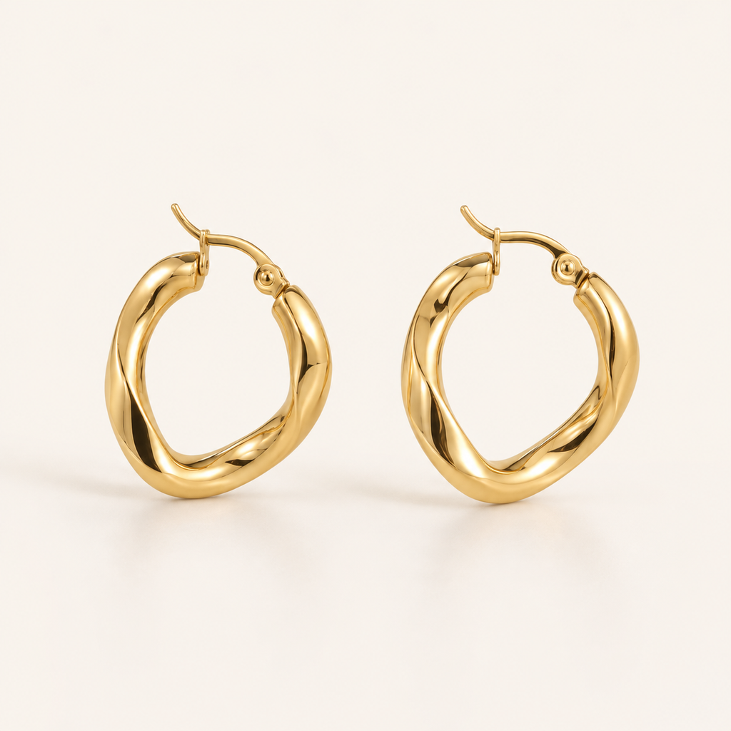 A pair of polished gold huggie hoop earrings with a twisted, organic design.