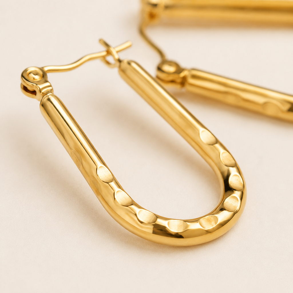 Gold u-shaped earrings with a hammered finish and fishhook backings.