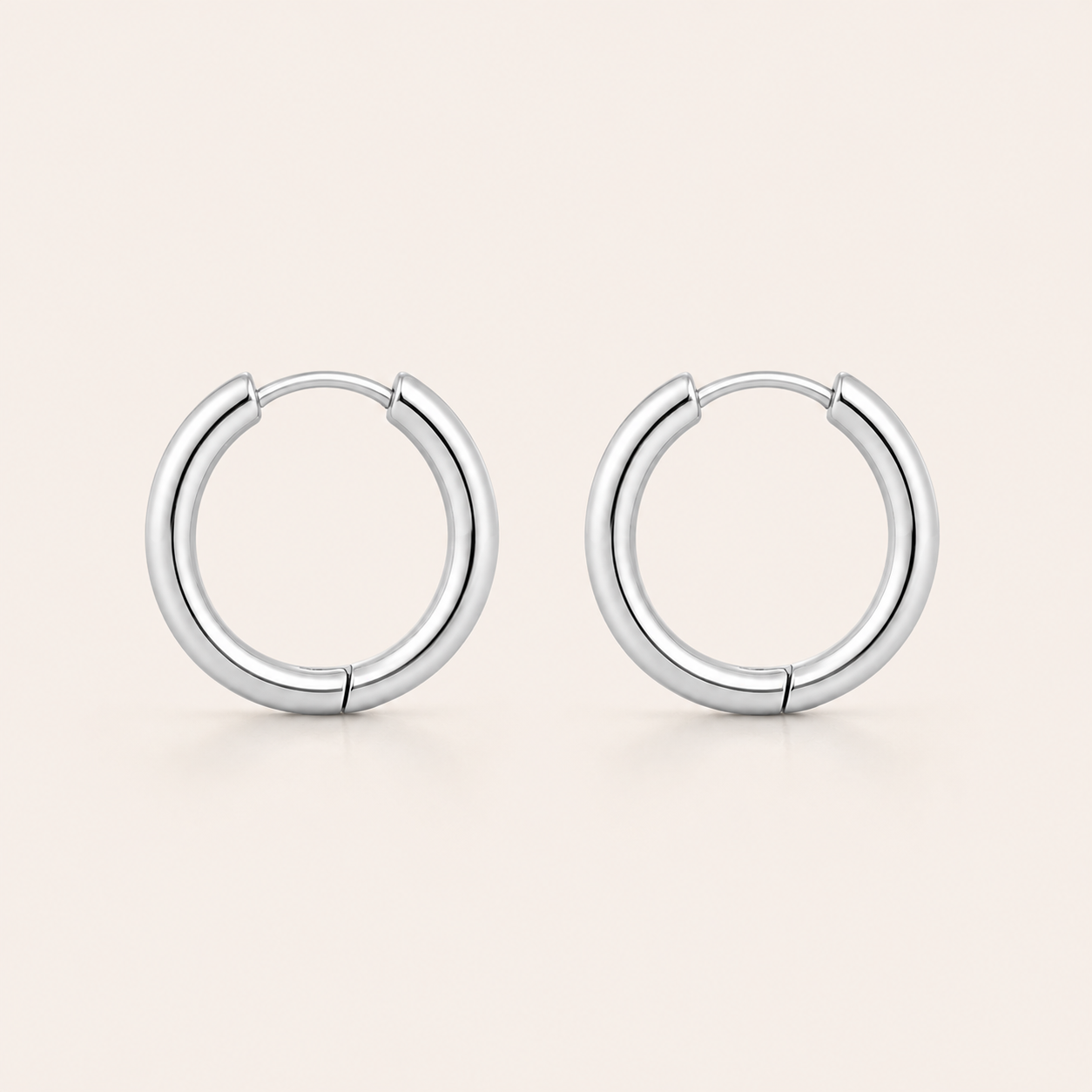 A pair of polished silver hoop earrings.