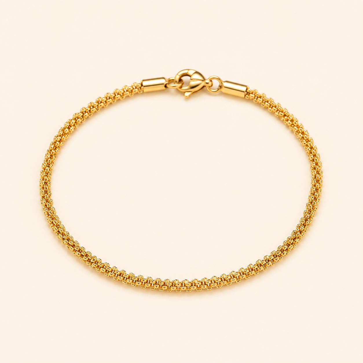 A gold chain bracelet with a textured woven-style design and a lobster clasp.