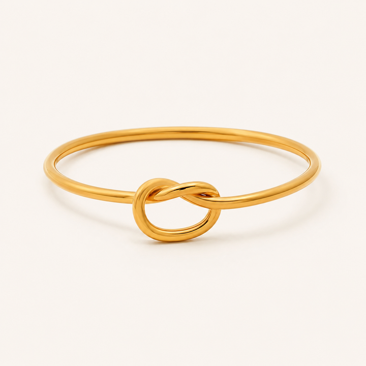 A polished gold ring featuring a central infinity love knot design.