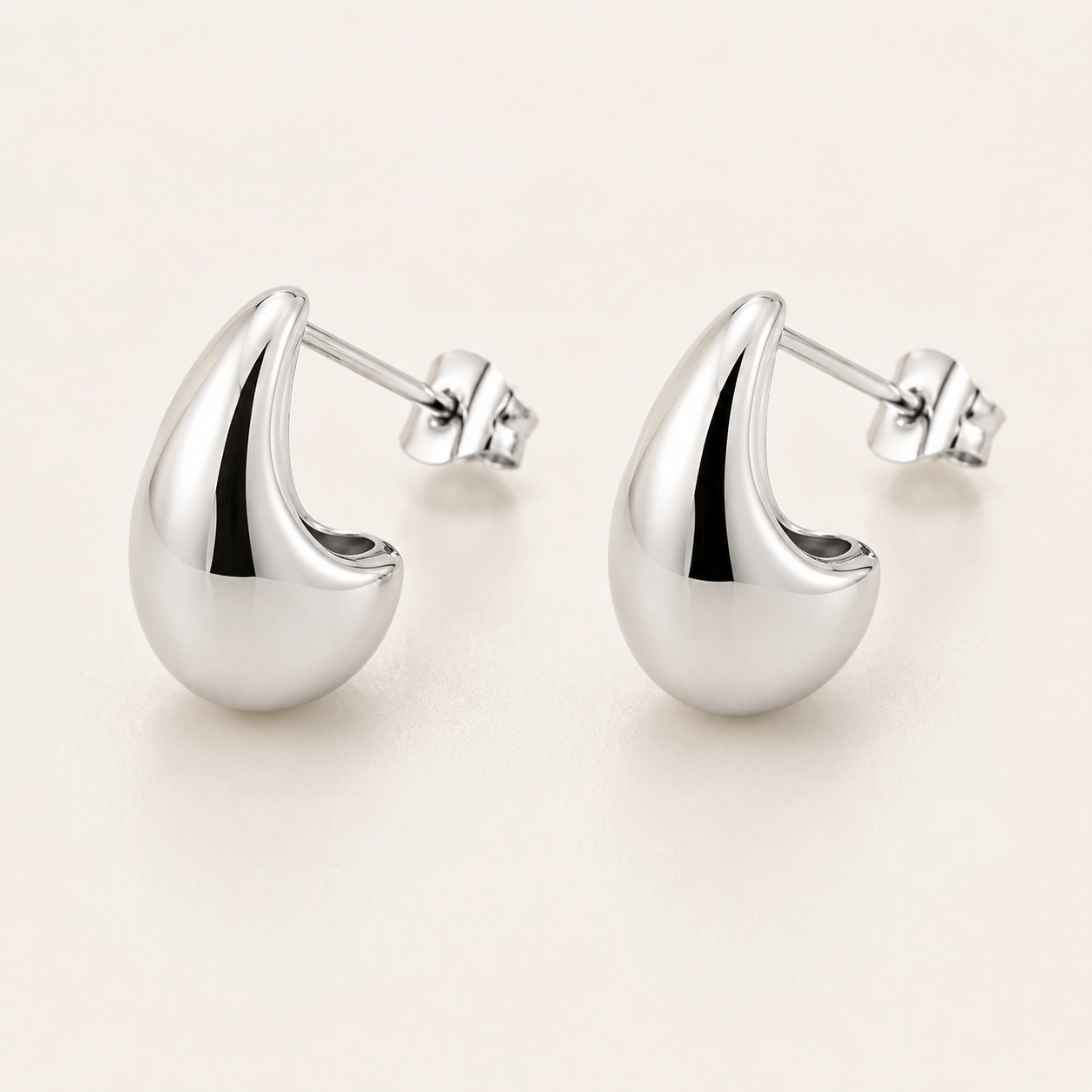 A pair of polished silver crescent-shaped stud earrings with post backs.