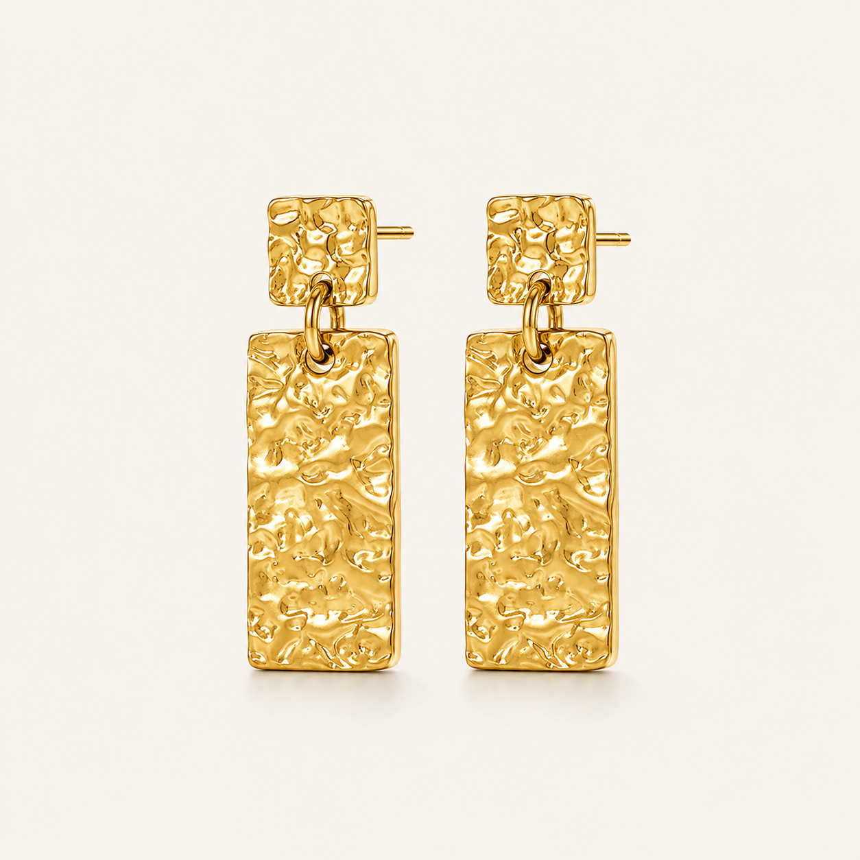 A pair of textured gold drop earrings with square post tops and rectangular dangling charms.