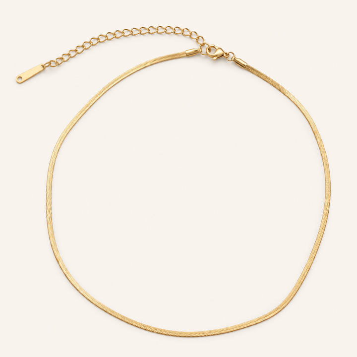A gold snake chain necklace with an adjustable lobster clasp and extension chain.