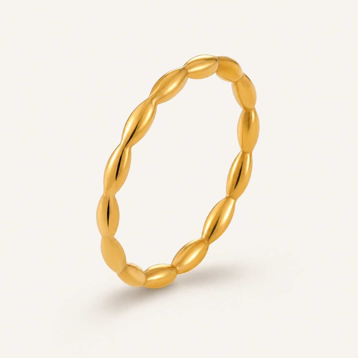 A single gold ring with a textured, twisted oval design.
