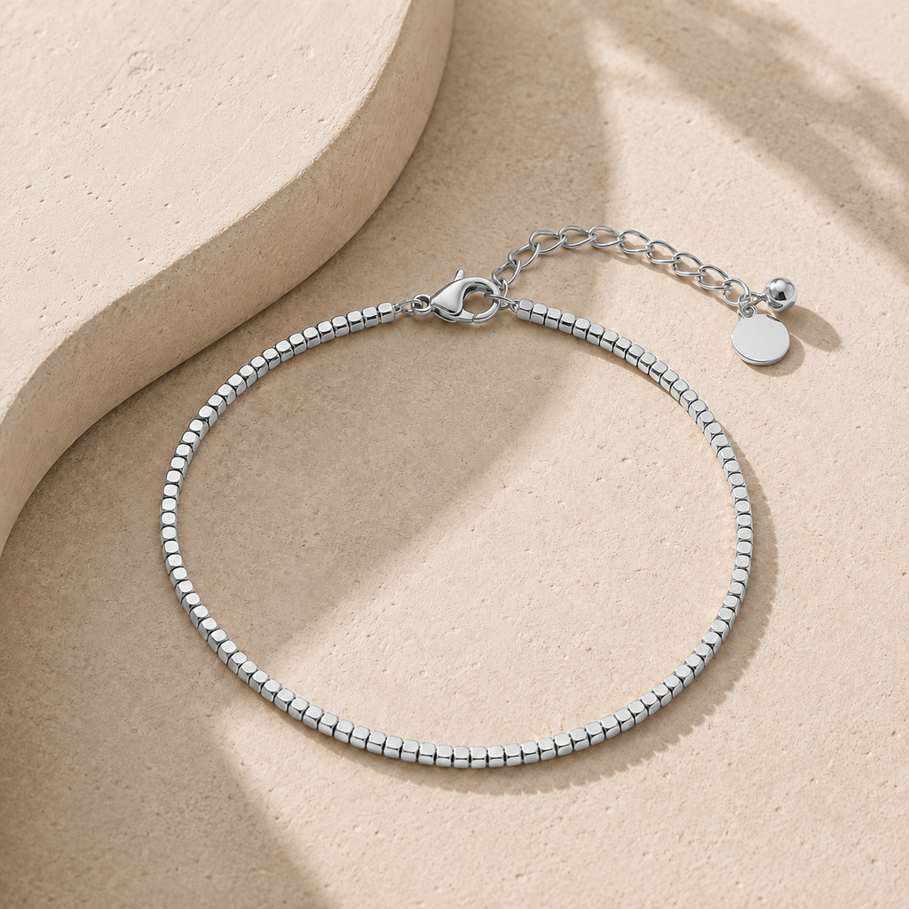 A silver beaded anklet with a lobster clasp and extension chain.