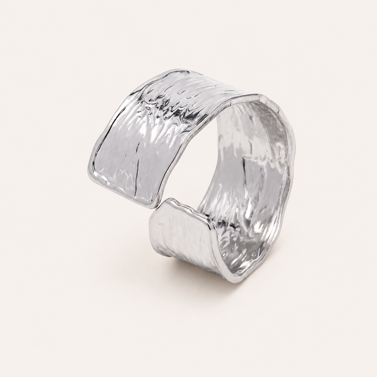 A wide, open cuff ring with a hammered, textured metallic finish.