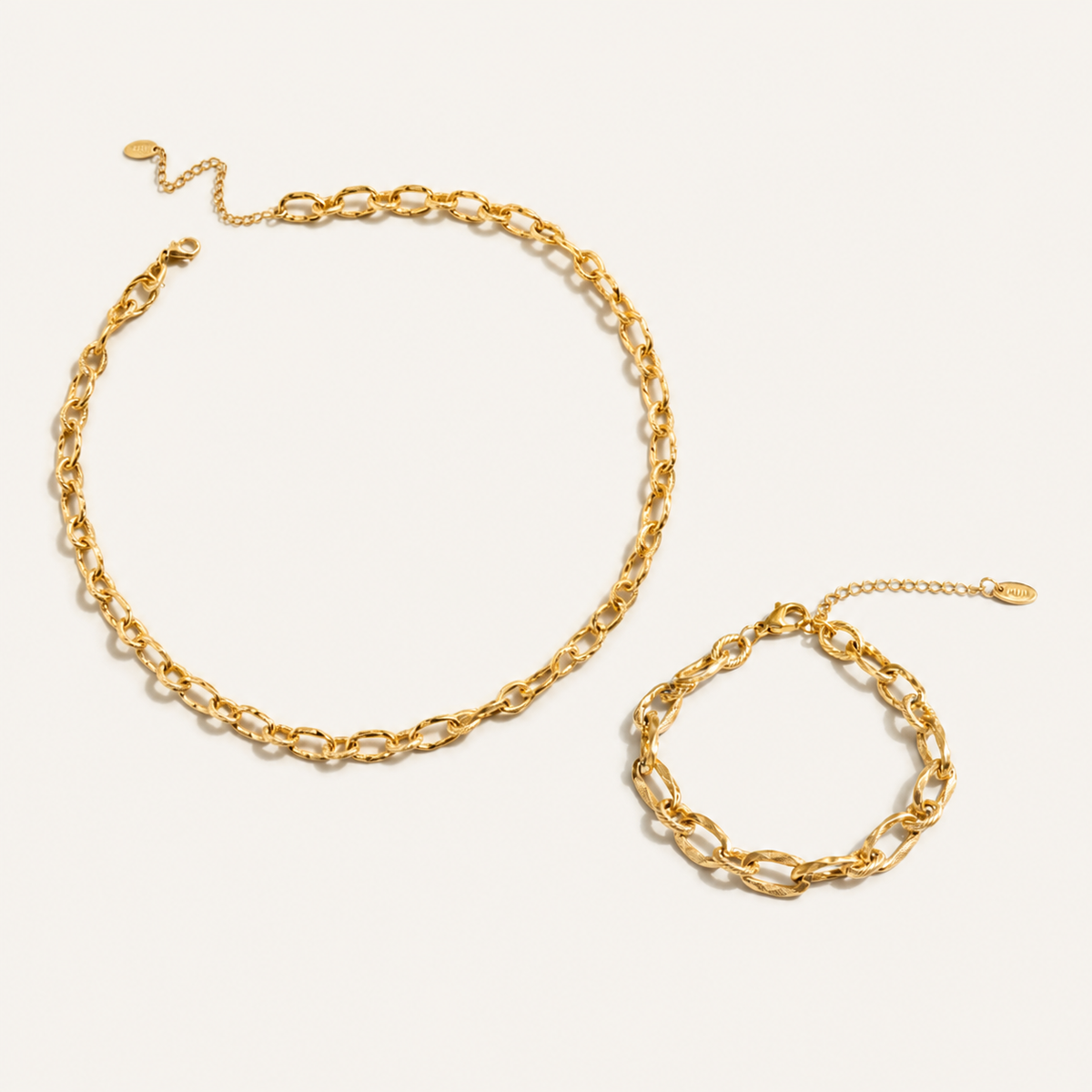A gold chain necklace and matching gold chain bracelet with elongated oval links.