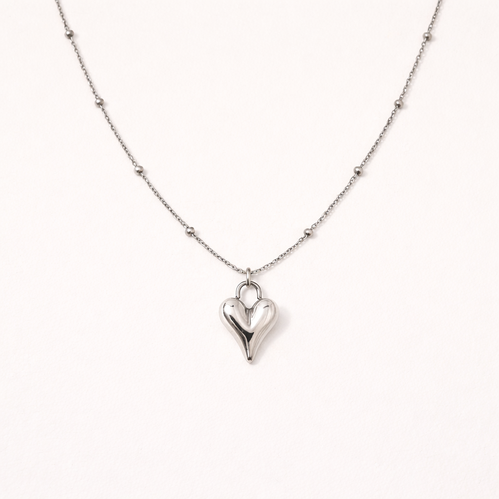 Silver heart-shaped pendant necklace on a white background