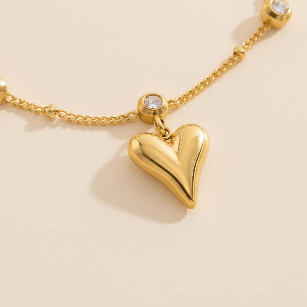 Gold heart-shaped pendant on a chain against a beige background