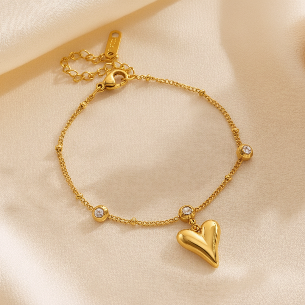 Gold bracelet with a heart charm on a beige background