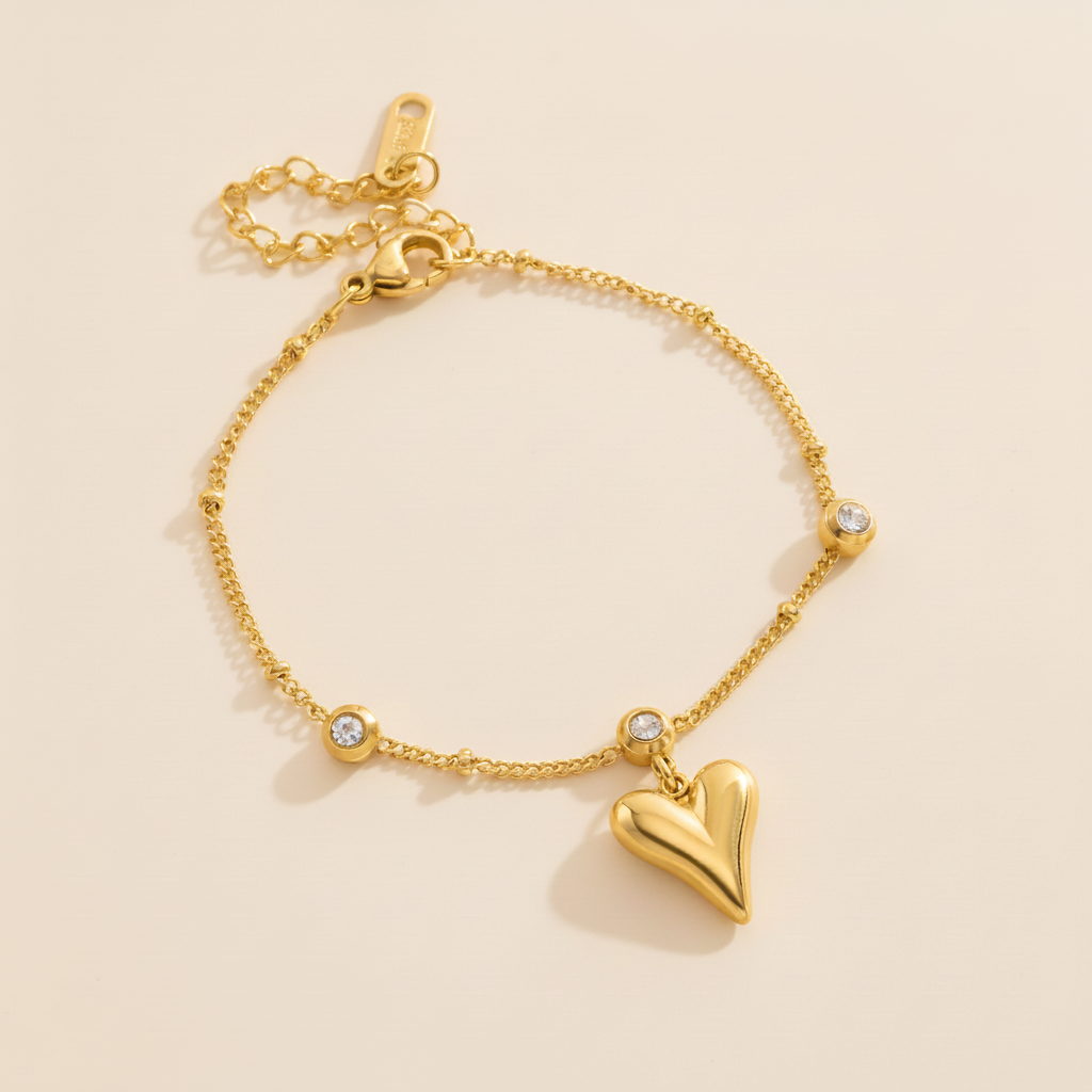 Gold heart-shaped bracelet on a beige background