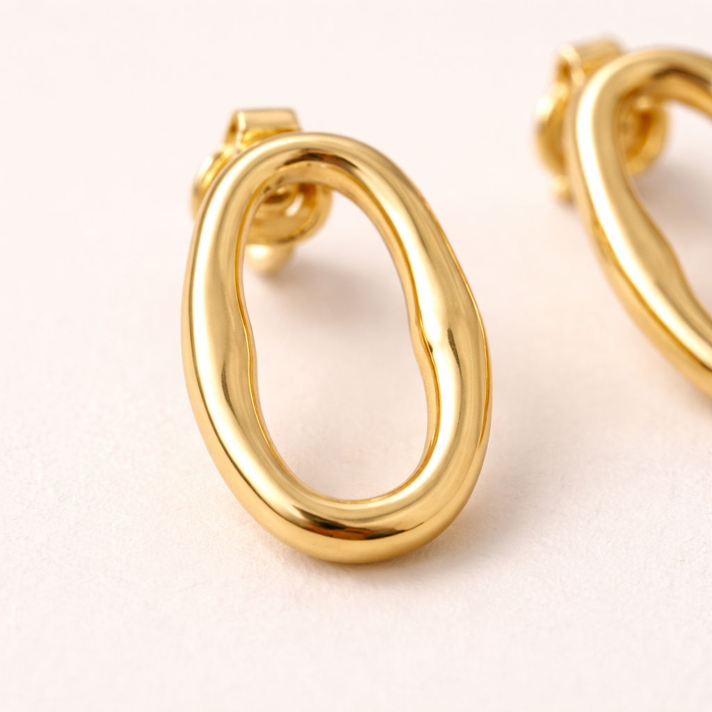 Close-up of oval earrings in gold