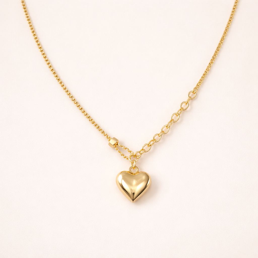 Gold heart-shaped pendant necklace on a light beige background